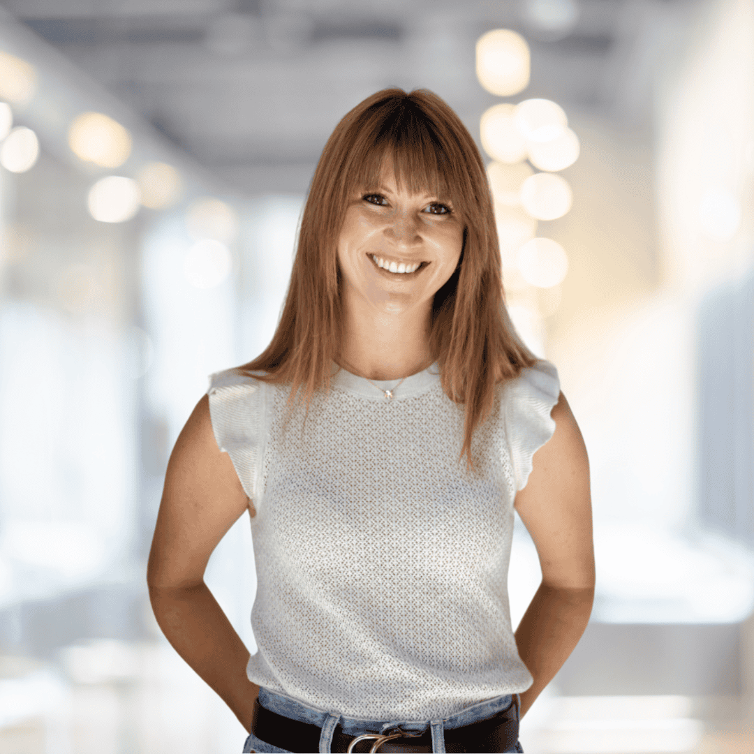Professional woman smiling confidently in a bright, professional environment, ideal for real estate branding.