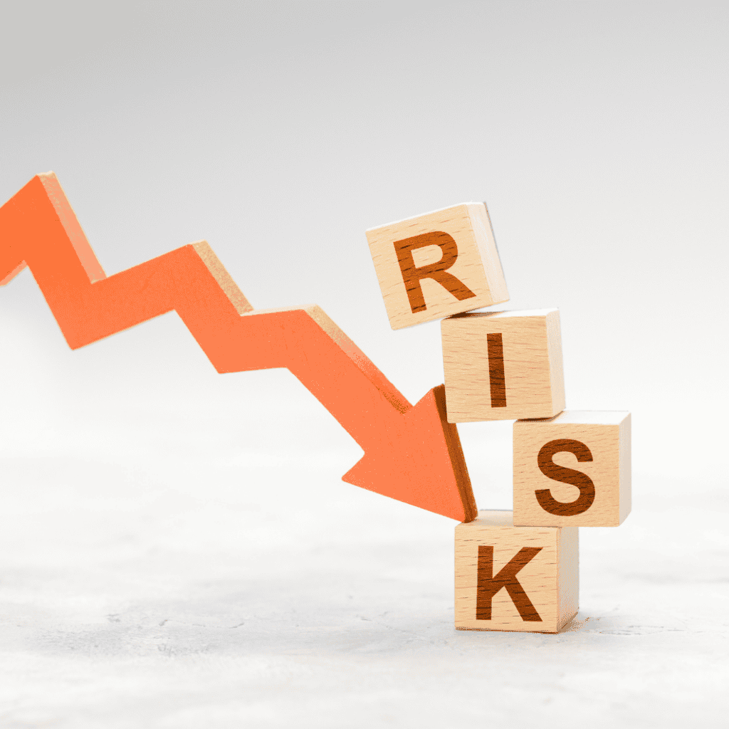 Wooden blocks spelling RISK with a downward arrow symbolizing financial risk.