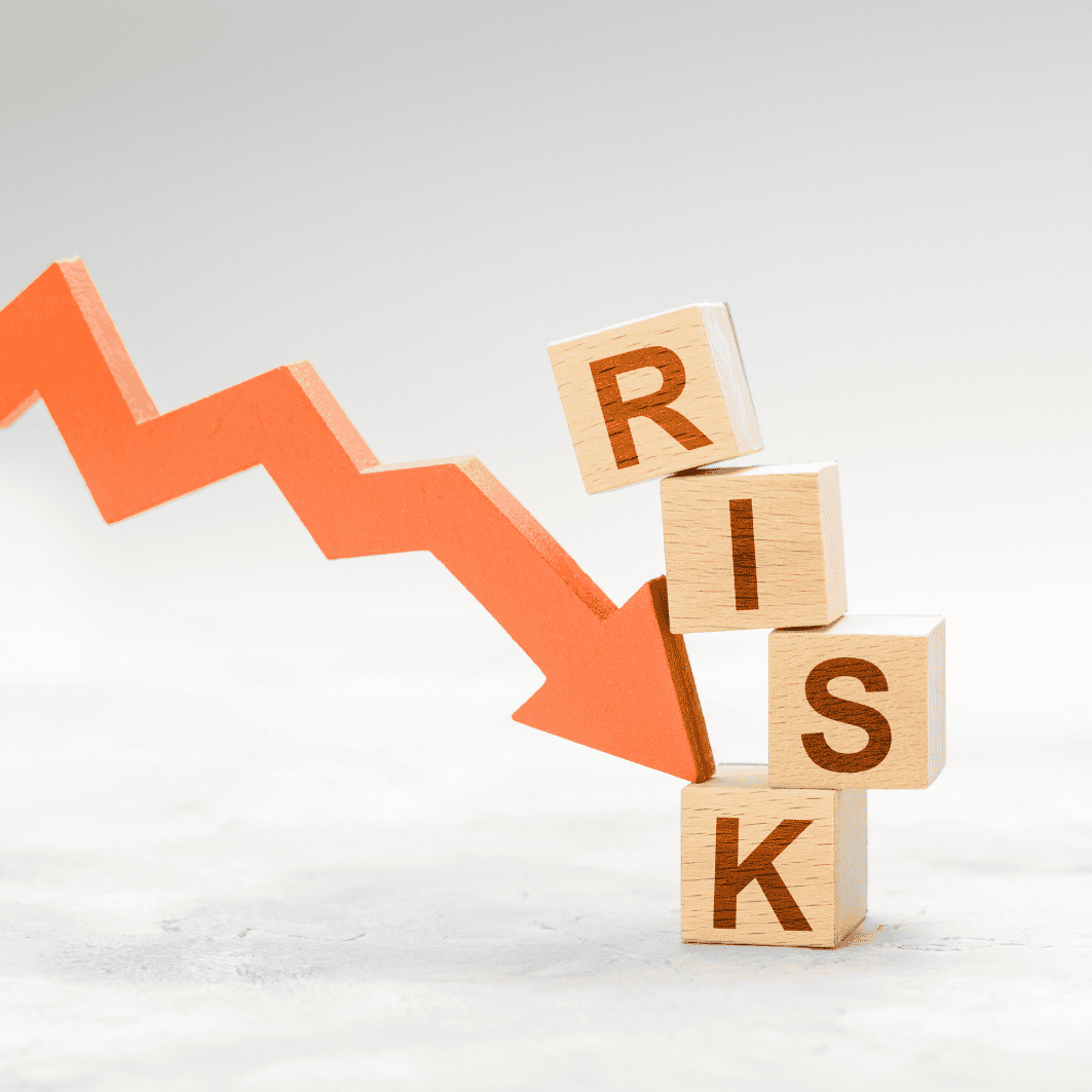 Wooden blocks spelling RISK with a downward arrow symbolizing financial risk.